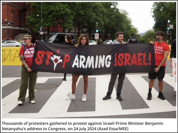 Photograph of four people standing in a Washington, D.C. crosswalk holding a black banner with red and white text reading: STOP ARMING ISRAEL! Caption text: Thousands of protesters gathered to protest against Israeli Prime Minister Benjamin Netanyahu’s address to Congress, on 24 July 2024 (Azad Essa/MEE)