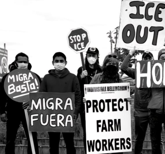Black and white photo of group of people holding signs. Sign texts: Migra Basta! / Migra Fuera / STOP ICE / Protect Farm Workers / ICE OUT